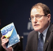 Claudio Sulser, chairman of the FIFA Ethics Committee quotes out of the code of ethics booklet during a press conference at the FIFA headquarters in Zurich, Switzerland, Thursday, Nov. 18, 2010. FIFA has suspended Amos Adamu and Reynald Temarii from the 2