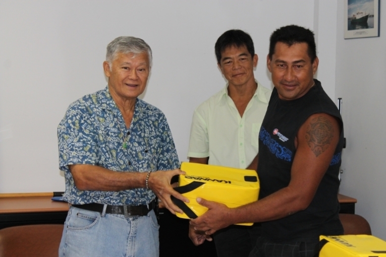 Temauri Foster, ministre des ressources marines et Stephen Yen Kai Sun procèdent à la remise d'une RLS.